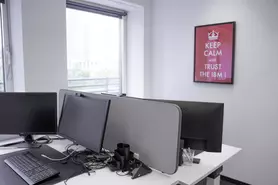 Desk with two monitors and picture on the wall