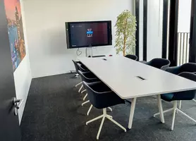Meetingraum mit großem Tisch und sechs Stühlen